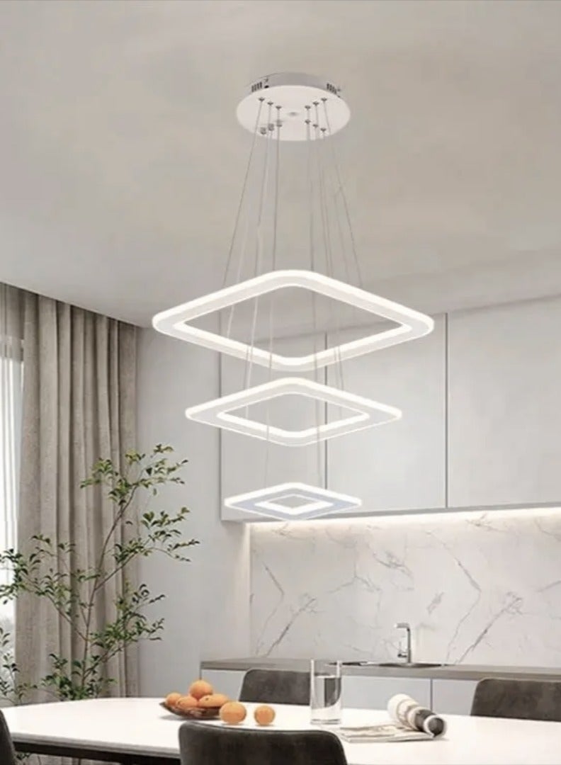 الثريات ثريا بتصميم هندسي يتكون من حلقات LED مربعة ب3 ألوان متدرجة،معلقة بأسلاك رفيعة تمنح الإحساس بالخفة والإنسيابية،تضفي هذه الثريا لمسة فنية ساحرة على المساحات الداخلية،مثالية  لغرفة المعيشة وغرفة الطعام مع جهاز تحكم عن بعد  - Image 1