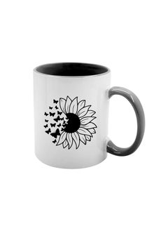 White ceramic mug with a printed design of a sunflower and a swarm of small butterflies on its edge replacing some petals