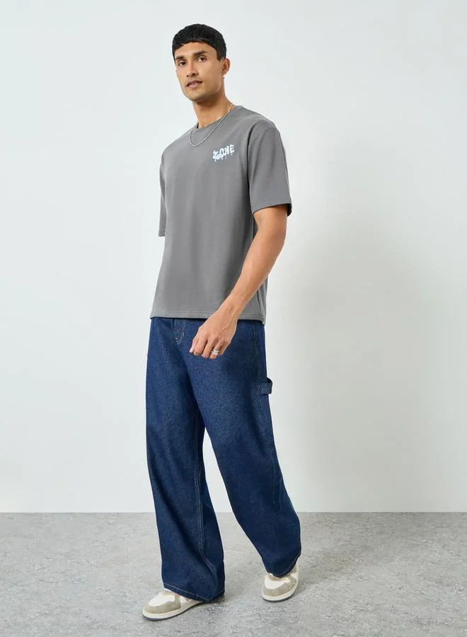 ستايلي تيشيرت رجالي واسع بطبعة جرافيك لون رمادي