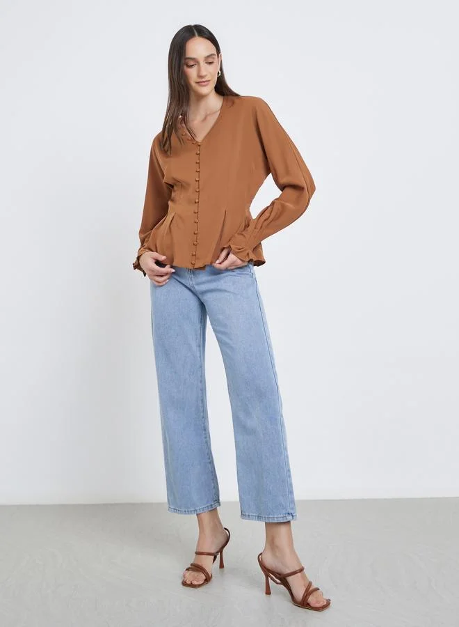 ستايلي بلوزة بتفاصيل أزرار وأكمام بالون