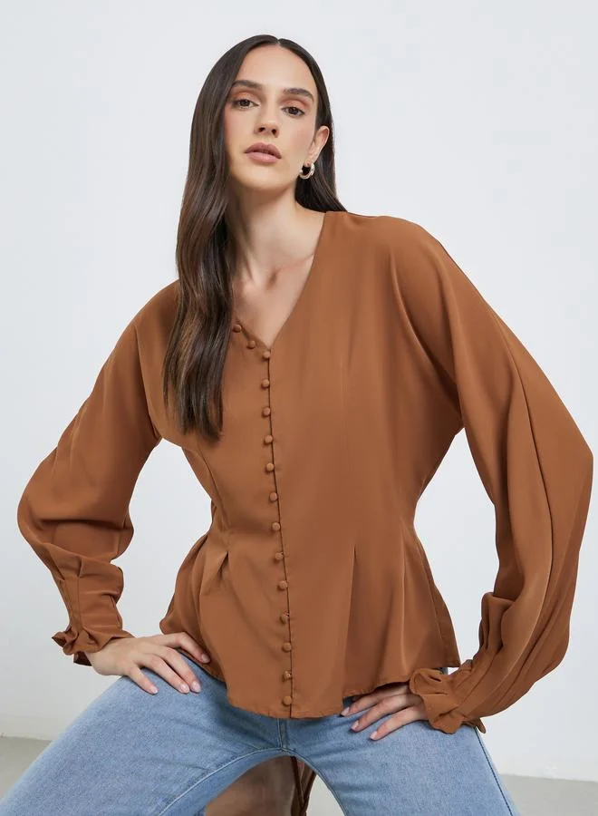 ستايلي بلوزة بتفاصيل أزرار وأكمام بالون