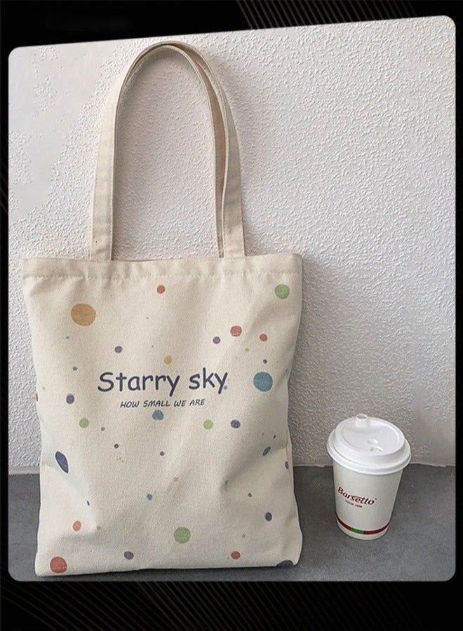 Joychic حقيبة قماشية جديدة قابلة للطي مطبوعة برسومات جرافيكية وحقيبة مدرسية كبيرة وخفيفة الوزن لحمل الأغراض اليومية للنساء باللون البيج - Image 2