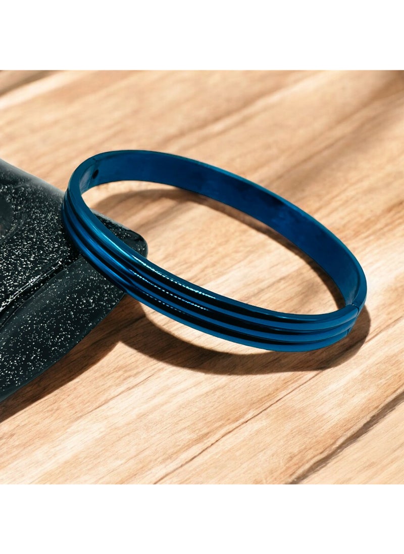 Elevate your accessory collection with this striking Triple Groove Metallic Blue Bangle Bracelet. Crafted from premium stainless steel, this modern piece features an eye-catching design with three parallel grooves that create a sophisticated dimensional effect. The stunning metallic blue finish adds a contemporary touch while maintaining a timeless appeal. The bangle's smooth, seamless construction ensures comfortable all-day wear, while its durable stainless steel composition offers excellent resistance to tarnishing and wear. Perfect for both casual and formal occasions, this bracelet can be worn alone as a statement piece or stacked with other bangles for a more dramatic look. The sleek design and premium craftsmanship make it an ideal choice for those who appreciate modern, minimalist aesthetics. Its versatile style complements any outfit, from business attire to evening wear, making it a valuable addition to your jewellery collection.