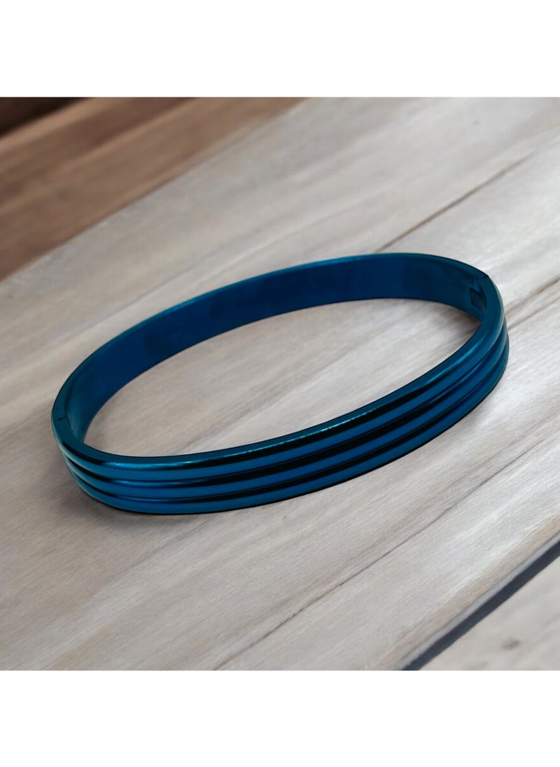 Elevate your accessory collection with this striking Triple Groove Metallic Blue Bangle Bracelet. Crafted from premium stainless steel, this modern piece features an eye-catching design with three parallel grooves that create a sophisticated dimensional effect. The stunning metallic blue finish adds a contemporary touch while maintaining a timeless appeal. The bangle's smooth, seamless construction ensures comfortable all-day wear, while its durable stainless steel composition offers excellent resistance to tarnishing and wear. Perfect for both casual and formal occasions, this bracelet can be worn alone as a statement piece or stacked with other bangles for a more dramatic look. The sleek design and premium craftsmanship make it an ideal choice for those who appreciate modern, minimalist aesthetics. Its versatile style complements any outfit, from business attire to evening wear, making it a valuable addition to your jewellery collection.