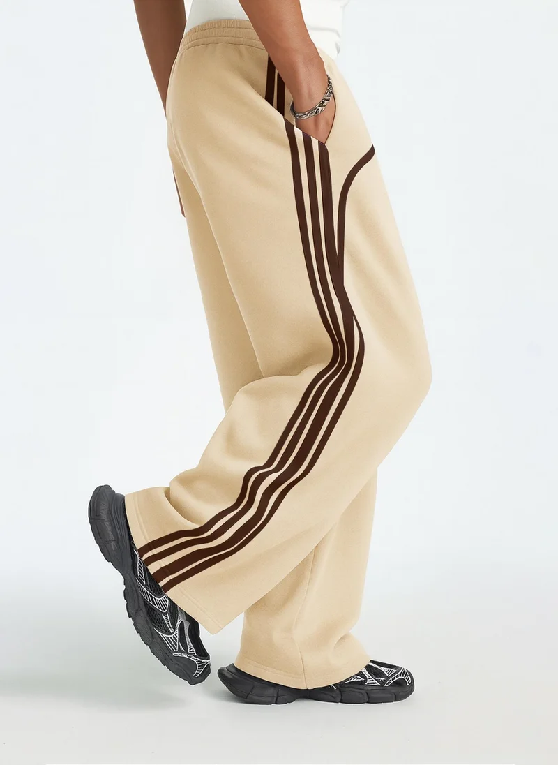 مانياك بنطلون رياضي رجالي واسع بقصة فضفاضة وخطوط جانبية بلون البسكويت والبني من القطن
