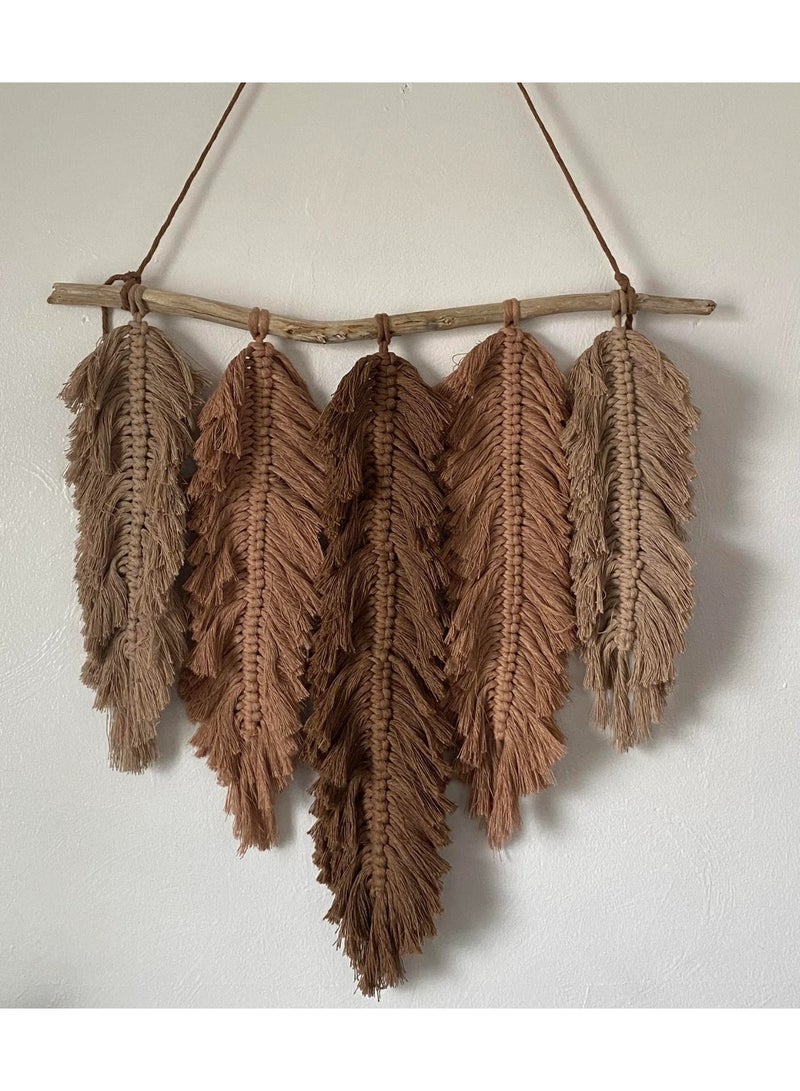 انتيكيانو تعليقة جدارية مكرمية أنيقة على شكل أوراق كبيرة، مصنوعة يدويًا من خيوط قطنية بألوان ترابية دافئة مثل البني والبيج. معلقة على غصن خشبي طبيعي يضيف لمسة ريفية وجذابة. تصميمها مستوحى من الطبيعة، ما يجعلها مثالية لإضفاء جو دافئ وهادئ في غرف المعيشة أو النوم أو المداخل. - Image 1