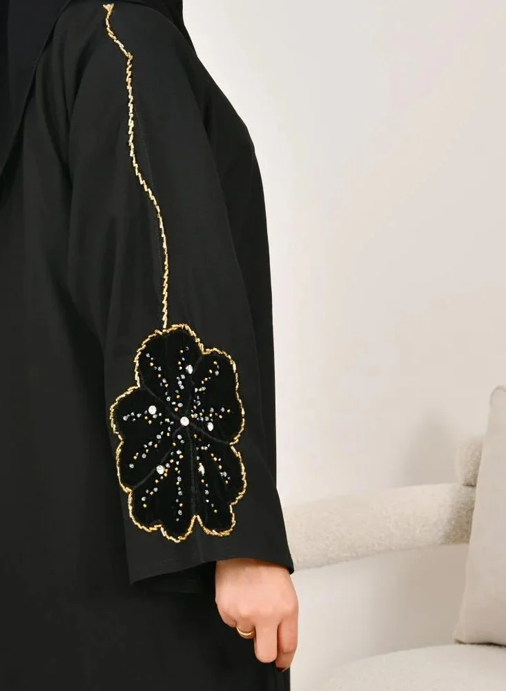 lamha abaya Black wrap abaya with prominent embroidery and black velvet overlay on flowers