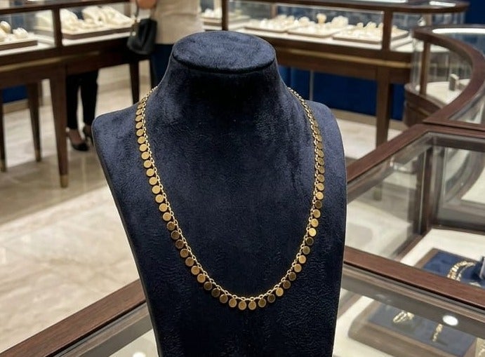Luxuria An elegant necklace featuring a delicate chain from which hangs a collection of small, solid, round pendants with a pleasing texture; a design that combines Middle Eastern and contemporary styles. - Image 3