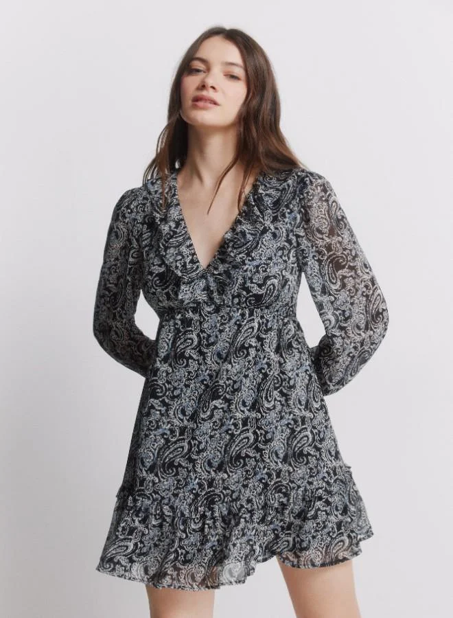 Springfield Printed long sleeve short dress. V-neck with ruffle. Cut below the bust. Skirt with double flounce. Ruffle detail on cuffs.