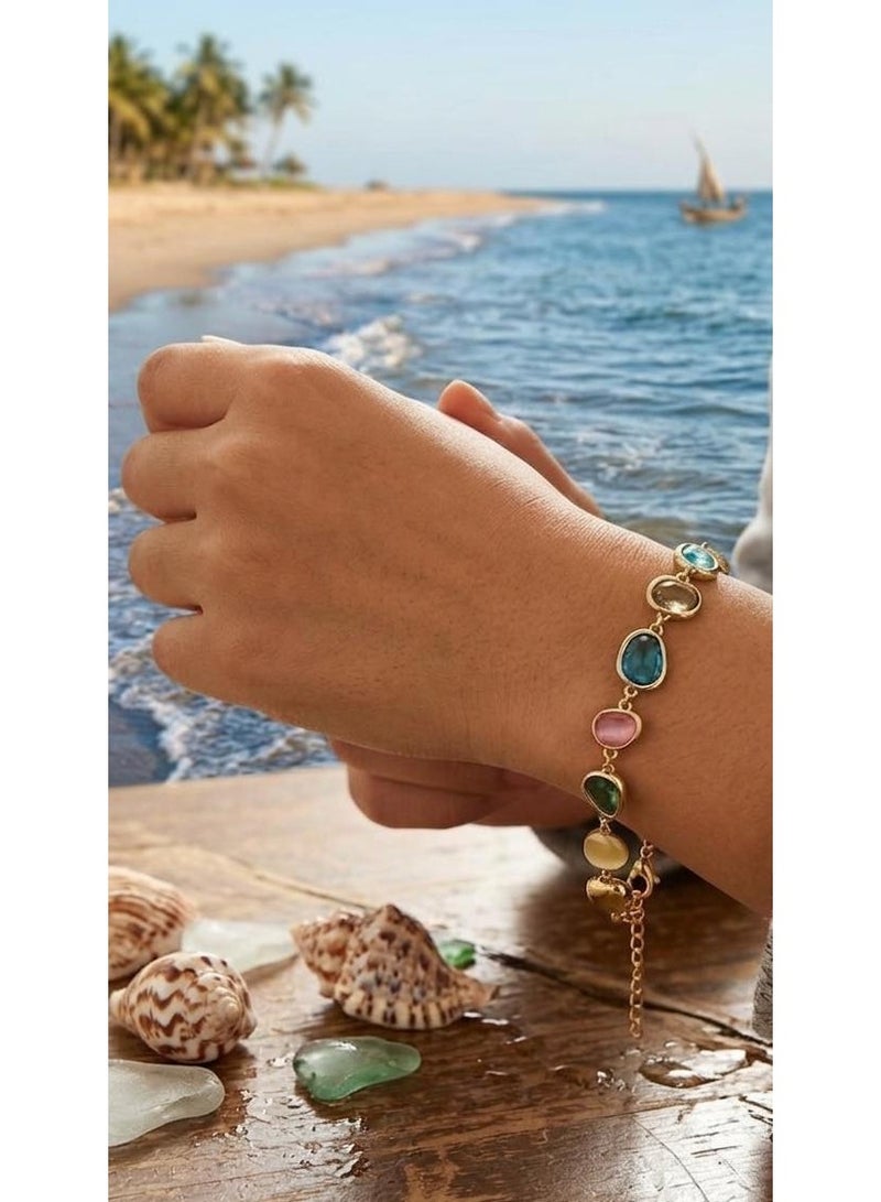 Luxuria An elegant gold bracelet adorned with colorful gemstones in oval and pear shapes, including shades of blue, pink, yellow, and green. - Image 1
