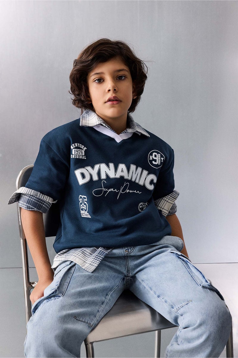 ديفاكتو تيشيرت بولو اولادي نص كم بطبعة شعار اوفر سايز وياقة عالية - Image 1