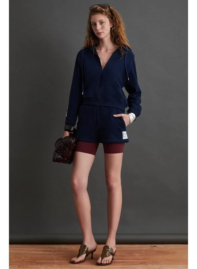 Ethiquet DANIXA Women's Mini Navy Shorts with 3-Thread Shirring and Decorative Tag Details.