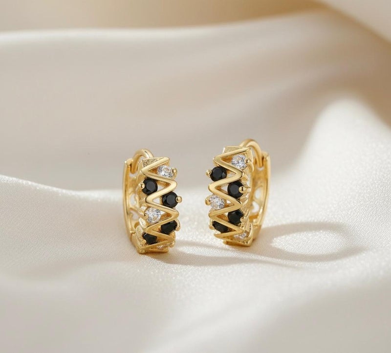Elegant gold earrings with a modern zigzag design, adorned with round black and silver cubic zirconia stones that give them exceptional sparkle. A bold and distinctive piece that adds a touch of beauty to your look. - Image 3
