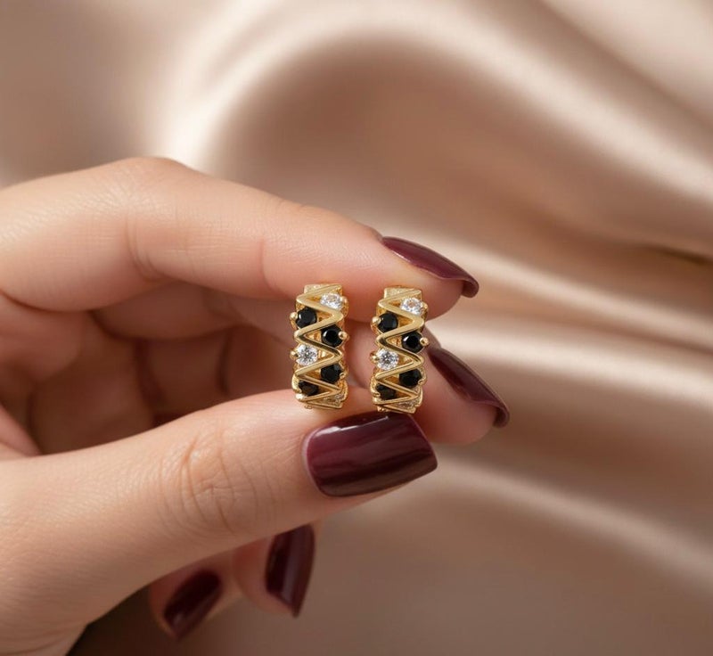 Elegant gold earrings with a modern zigzag design, adorned with round black and silver cubic zirconia stones that give them exceptional sparkle. A bold and distinctive piece that adds a touch of beauty to your look. - Image 4