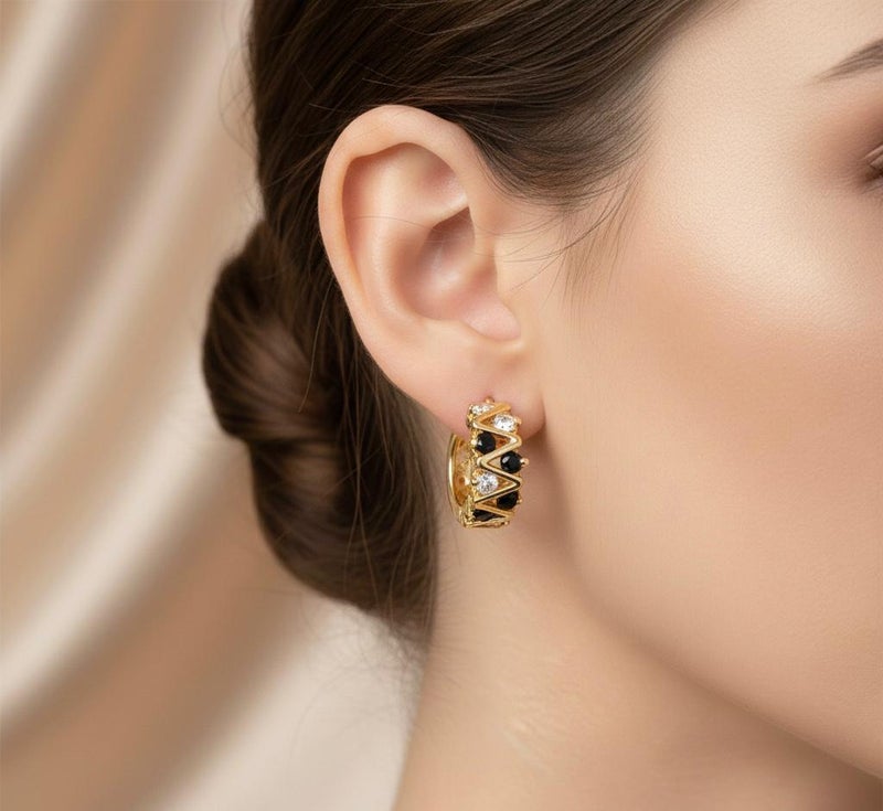 Elegant gold earrings with a modern zigzag design, adorned with round black and silver cubic zirconia stones that give them exceptional sparkle. A bold and distinctive piece that adds a touch of beauty to your look. - Image 2