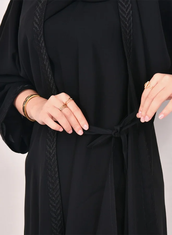 HAWRAA ABAYA Black wrap abaya with a connected dress decorated with spikes on the edges of the abaya and the sleeves