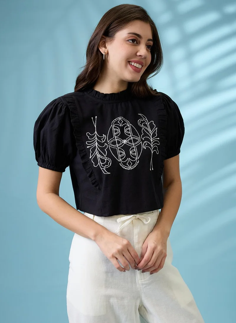 جلو باص بلوزة نسائية قصيرة بياقة عالية وأكمام منفوشة وتفاصيل مطرزة وكشكشة