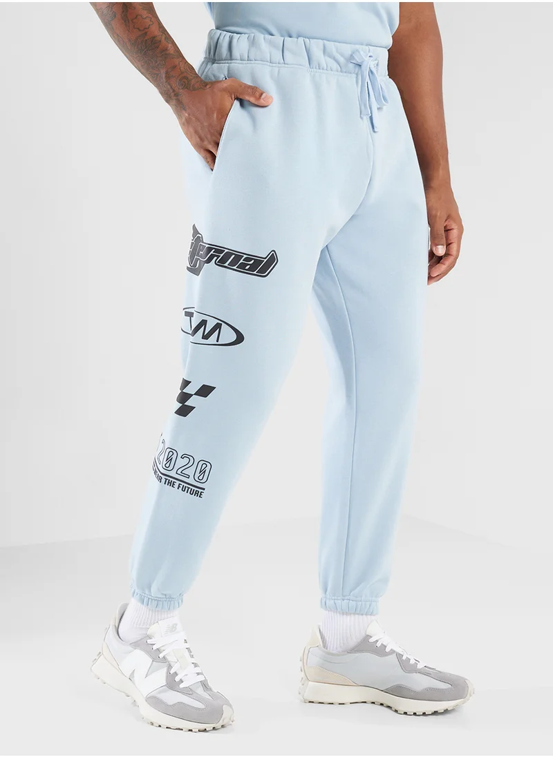 ذا جيفينج موفمنت Relaxed Fitted Racing Printed Sweatpants