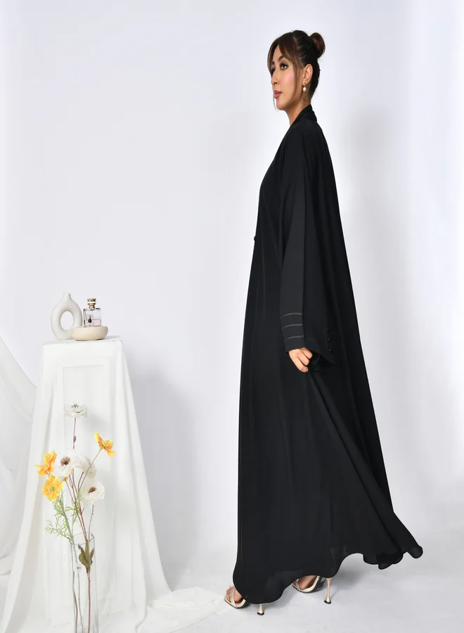 HAWRAA ABAYA Cloche abaya with closed buttons, decorated with ribbons and buttons