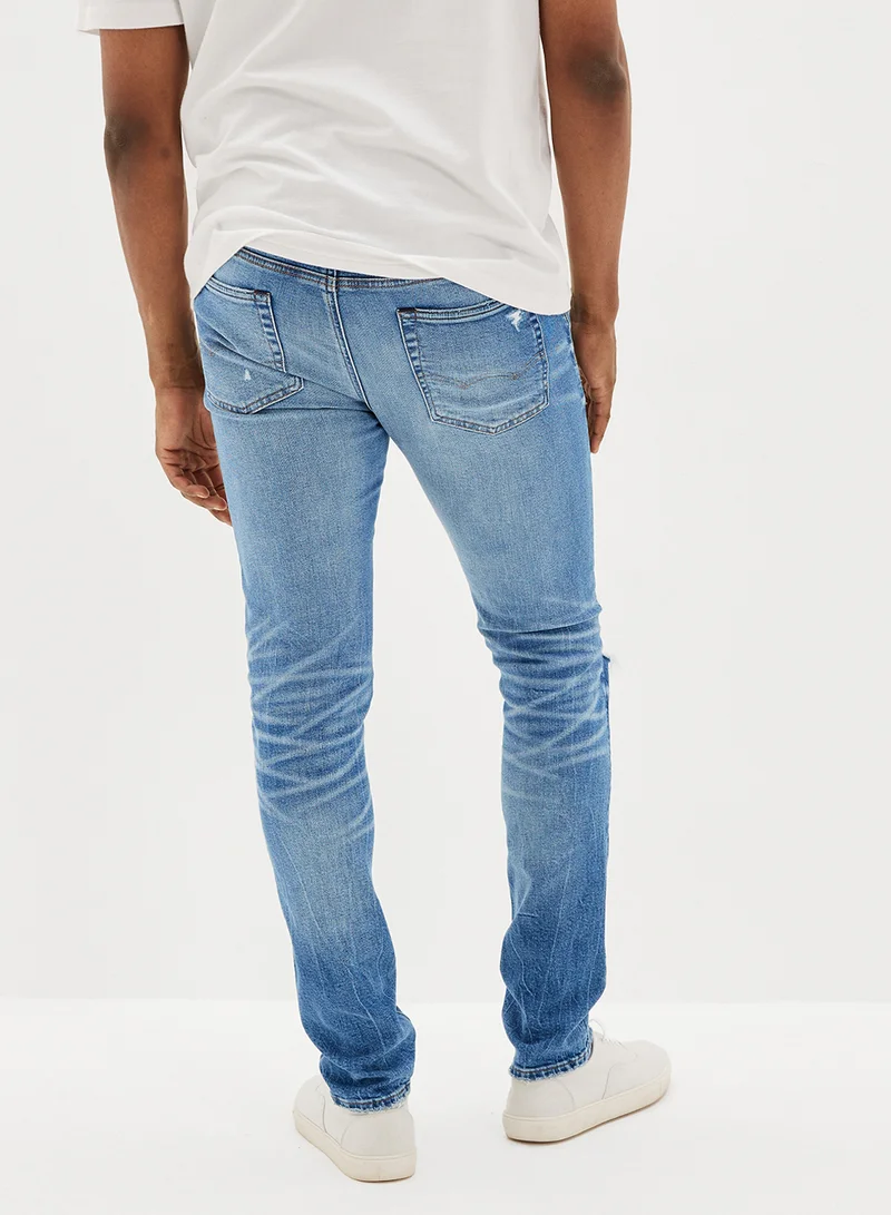 American Eagle Airflex+ Patched Slim Fit Mid Wash Jeans
