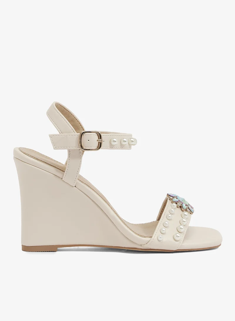 Ivory wedge sandal with pearl straps and crystal brooch