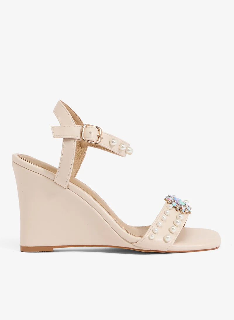 Ivory wedge sandal with pearl straps and crystal brooch