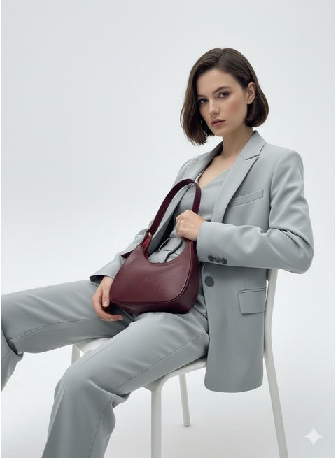 Stylish shoulder bag with a modern design and glossy finish featuring a zip closure.