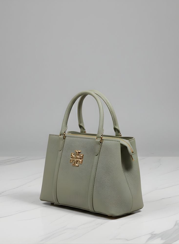 بريميم حقيبة يد نسائية بتصميم أنيق باللون الأخضر الزيتوني، مزينة بشعار ذهبي ونقشة محببة. - Image 1