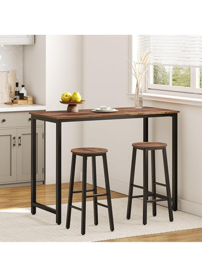 3-piece dining table set, consisting of one high table and two high chairs. It is a high-height kitchen table with seats in a modern and contemporary design and a steel frame. It is placed in the kitchen, dining room, living areas, and social areas. It is a rustic brown color with a black metal frame. It is durable and can be used in the kitchen, living room, dining room, or office. You can use the table as a coffee corner, a work desk, an entrance console, behind the sofa, or as a buffet for appetizers and drinks when needed. The chairs can be used during occasions as additional chairs or as a corner table. In some corners, vases or plant pots can be placed on it. The seat is round and has a soft texture that is not scratched. The chair has comfortable footrests when sitting on it. These details and design touches make you sit more comfortably. Easy to assemble and assemble