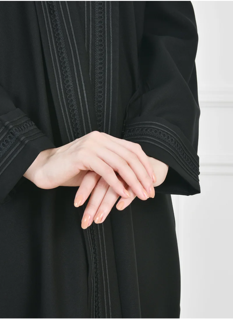 HAWRAA ABAYA Black wrap abaya with a practical design, decorated with veils on the edges of the abaya and sleeves with side pockets