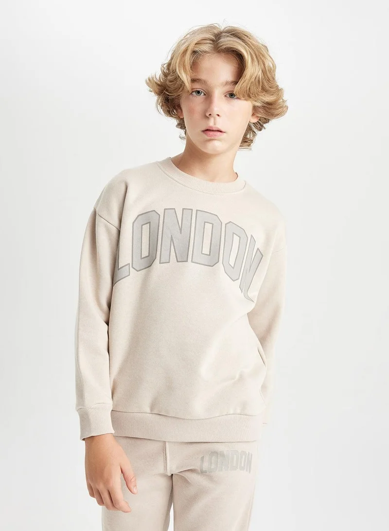 ديفاكتو سويت شيرت مدرسي سميك بقصة واسعة وياقة دائرية بلون بيج