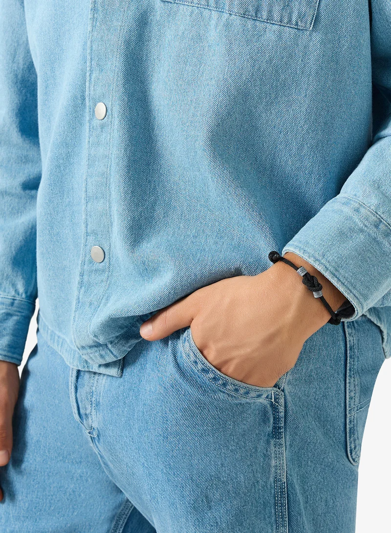 Seventy Five Cord Bracelet Featuring Central Knot Motif