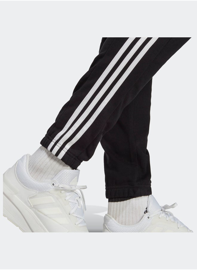 Adidas بنطال رياضي أساسيات فرينش تيري بأساور مطاطية مدببة بثلاثة خطوط  - Image 5