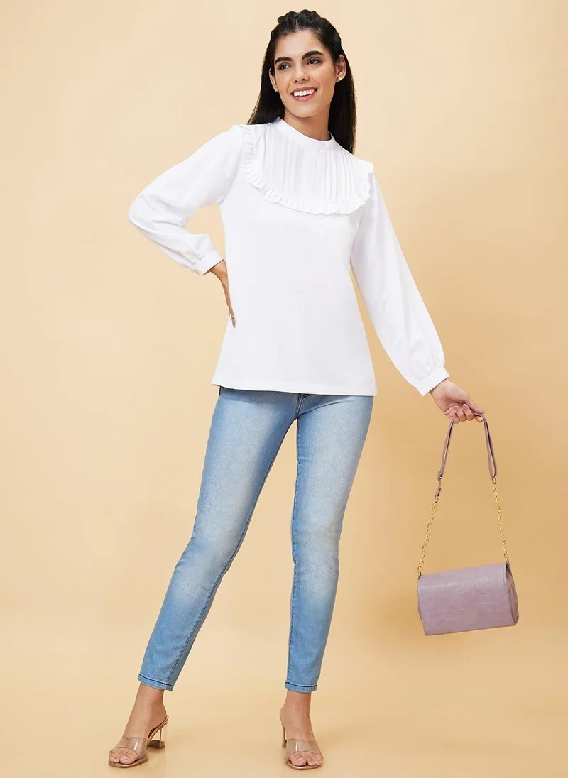 جلو باص بلوزة نسائية بيضاء فاتحة بياقة عالية وتفاصيل مجعدة أو مطوية