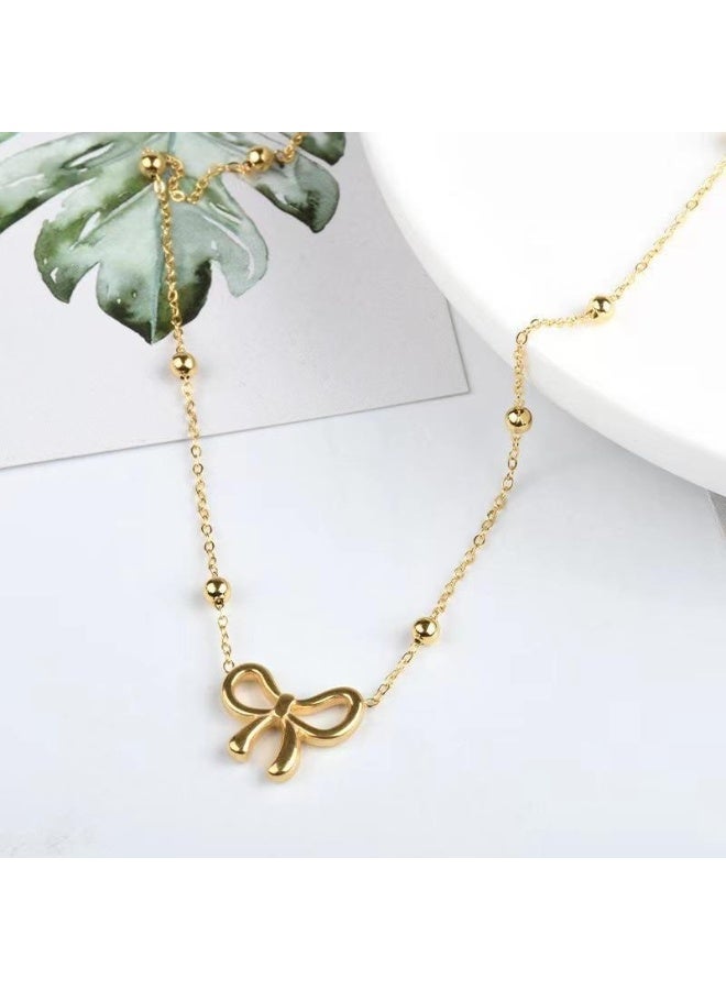 يوكانبي طقم مجوهرات أنيق من ٤ قطع للنساء – عقد، سوار، حلق وخلخال بتصميم فيونكة | من التيتانيوم باللون الذهبي - Image 4