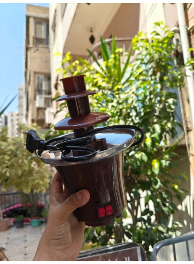 حلي أي قعدة ولمة عيلة بلمسة من السعادة! ✨🍫  وصلت الآن نافورة الشوكولاتة الكهربائية الـ 3 طبقات الأكثر طلباً! 😍 الماكينة السحرية اللي هتحول بيتك لكافيه، وتفرح أولادك وضيوفك في أعياد الميلاد والمناسبات . ليه الماكينة دي لازم تكون في بيتك؟ 🍓 مثالية لغمس الفواكه (الفراولة، الموز)، المارشميلو، والبسكويت . ⚙️ عملية جداً ومصنوعة من مواد آمنة وسهلة التنظيف والتفكيك. 🔥 حجمها مثالي ومزودة بزر تسخين للحفاظ على الشوكولاتة سايحة وسلسة طول الوقت - Image 1