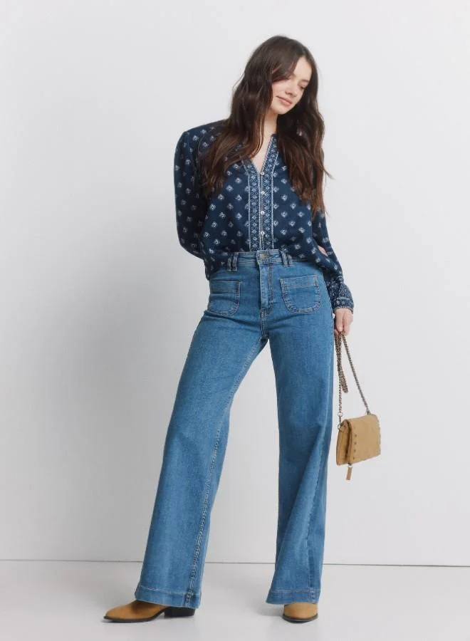 سبرينجفيلد قميص طويل الأكمام مطبوعة وضخم. ياقة دائرية مع فتحة على شكل V. الأزرار الأمامية. أصفاد مطاطية. هذا القطعة مصنوعة من القطن المستدام بنسبة 100٪.