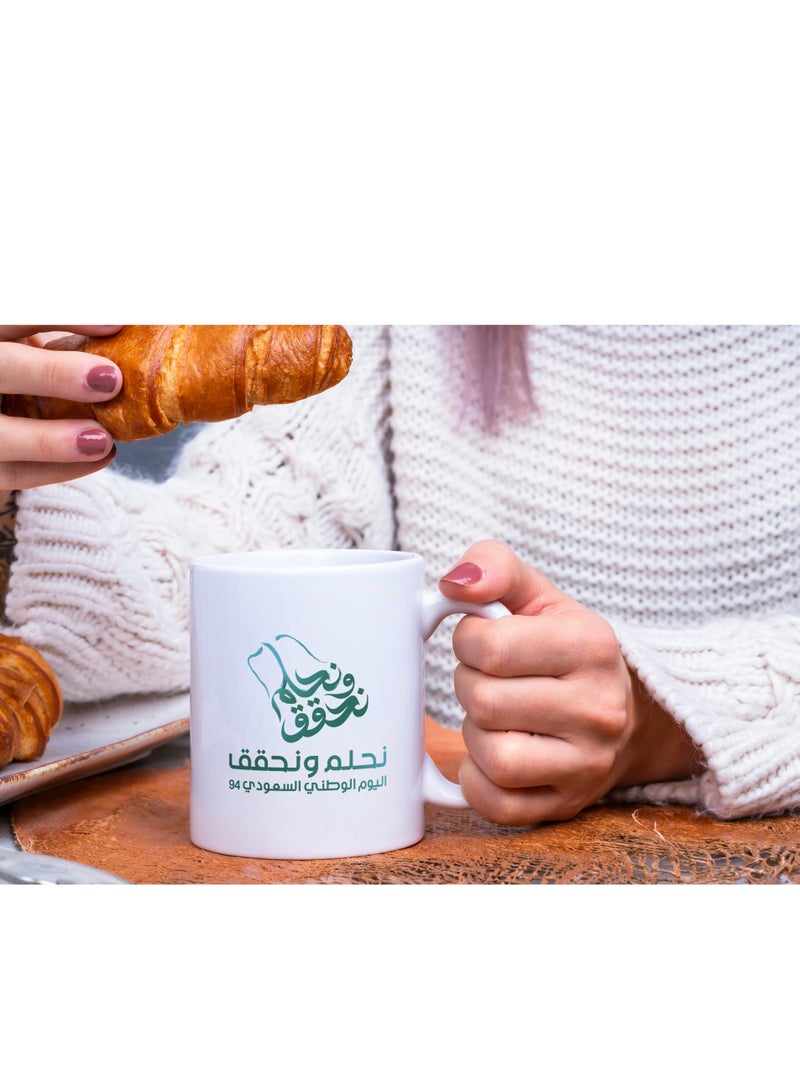 حكاية شمعة مج من السيراميك بطبعة تصميم "شعار اليوم الوطني 94" بلون أبيض - Image 4