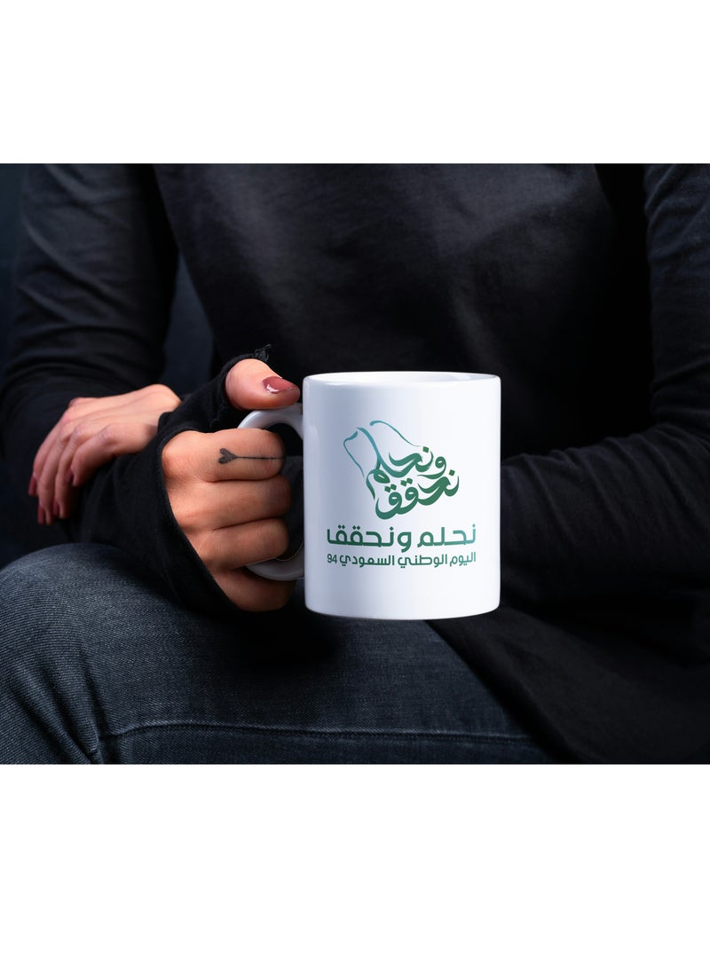 حكاية شمعة مج من السيراميك بطبعة تصميم "شعار اليوم الوطني 94" بلون أبيض - Image 2