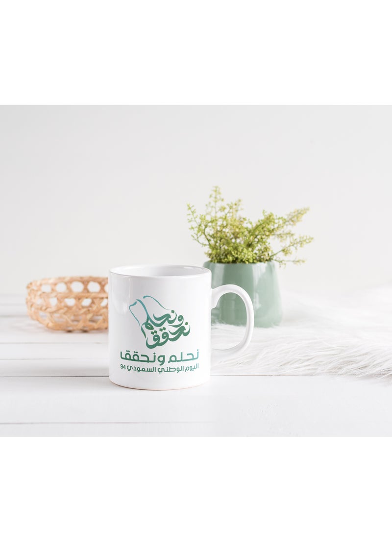 حكاية شمعة مج من السيراميك بطبعة تصميم "شعار اليوم الوطني 94" بلون أبيض - Image 5