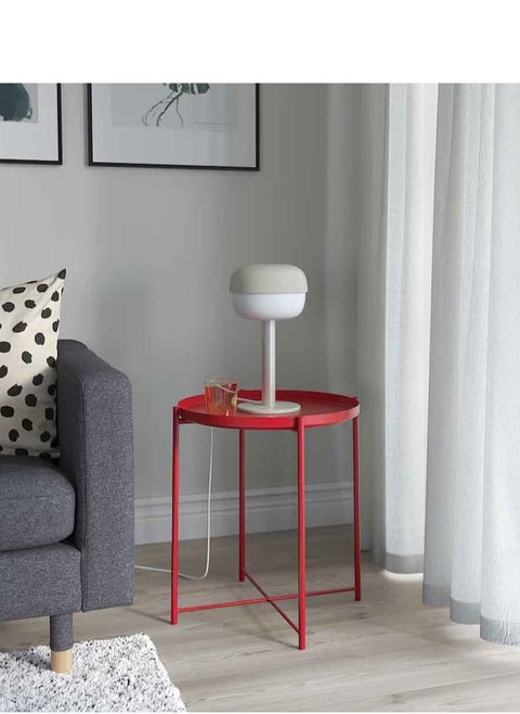 Red metal table in the form of a circular tray