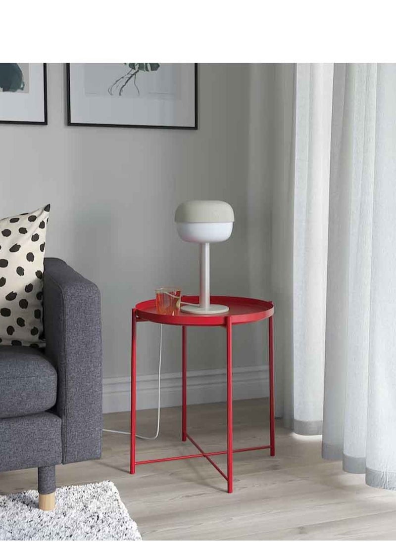 Red metal table in the form of a circular tray