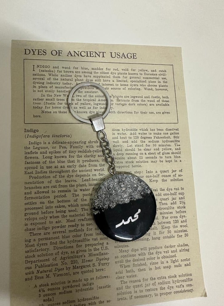 A key pendant with an elegant design with a name embroidered with silver leaf, suitable for all types of keys.