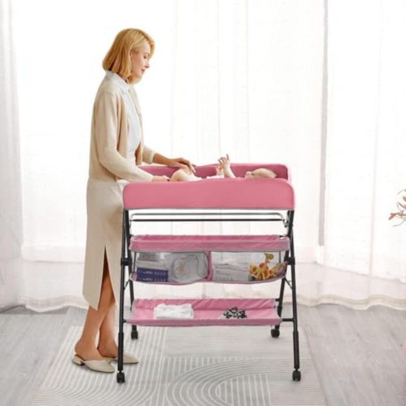 Portable baby changing table with wheels for nursery use, made of durable plastic in pink color, featuring adjustable height, folding design, and integrated storage rack for convenience and space-saving. - Image 2