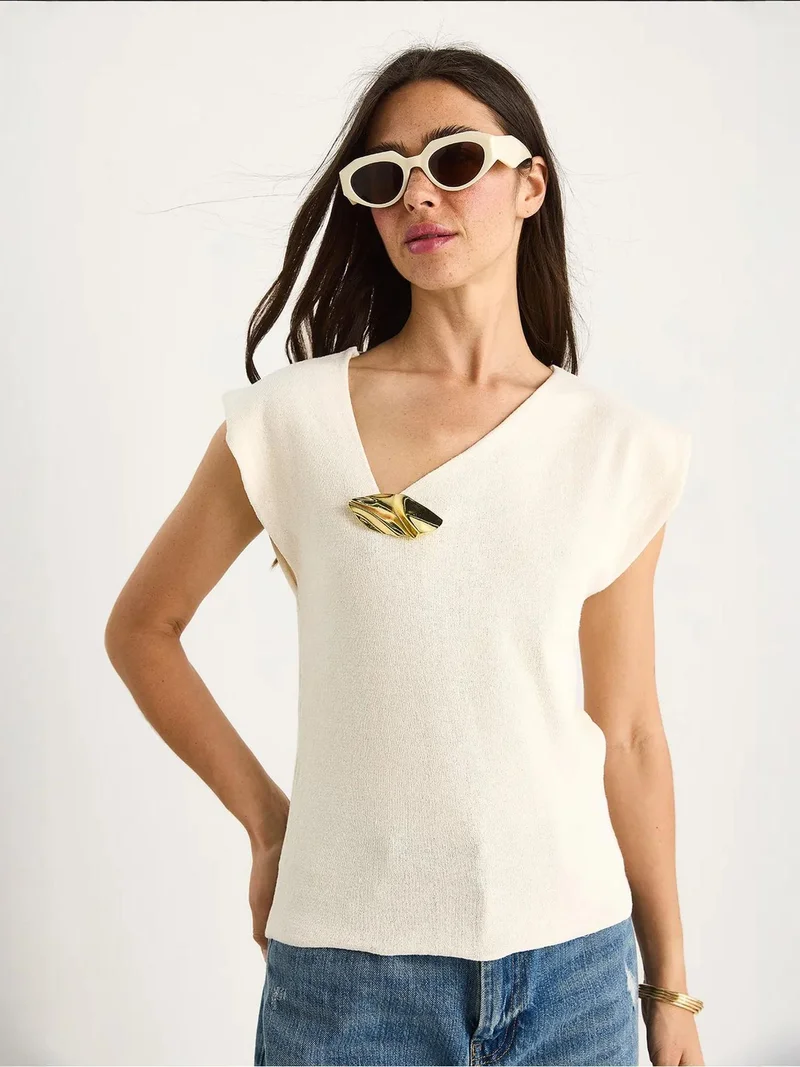 بيانكو لوتشي بلوزة لوكسي بدون أكمام بياقة على شكل حرف  مع تفاصيل إكسسوار