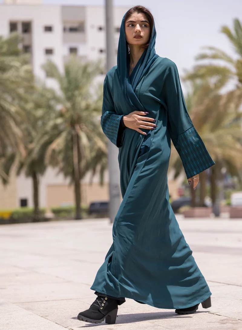 فاشون لاين عباية بتصميم فريد بياقة على شكل حرف  وأكمام مطرزة باللون الأزرق المخضر