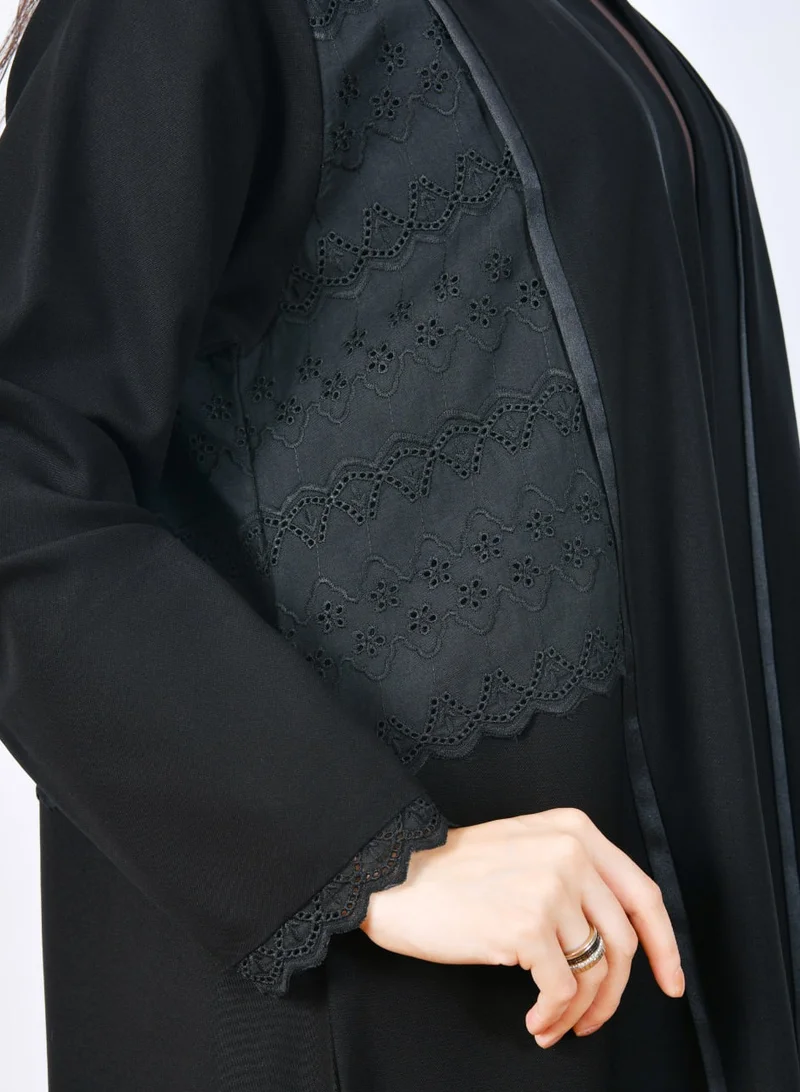 HAWRAA ABAYA Elegant abaya with an overlapping design featuring openwork fabric embellished with a soft satin ribbon along the front.