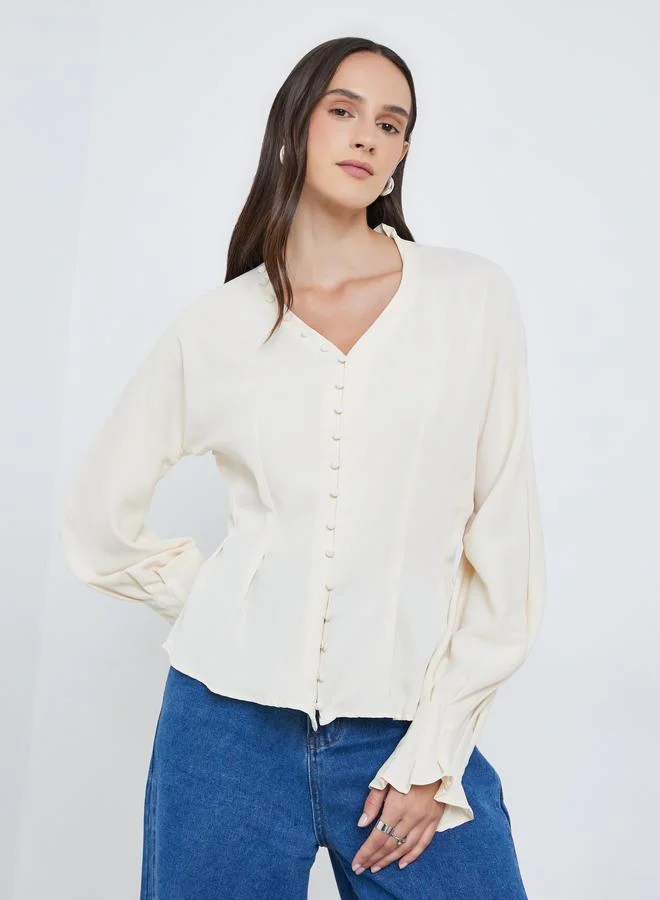 ستايلي بلوزة بتفاصيل أزرار وأكمام بالون