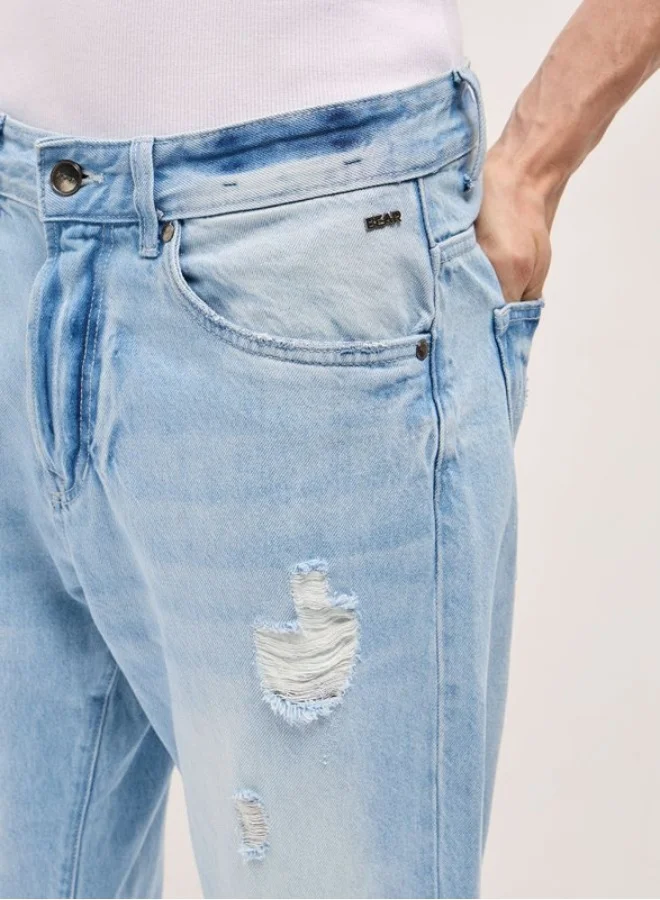 ذا بير هاوس جينز رجالي أزرق فاتح بتصميم باهت وممزق، خصر متوسط، قصة مريحة، راحة كلاسيكية بلمسة عصرية، مثالي للإطلالات اليومية الكاجوال وأجواء الشارع الأنيقة