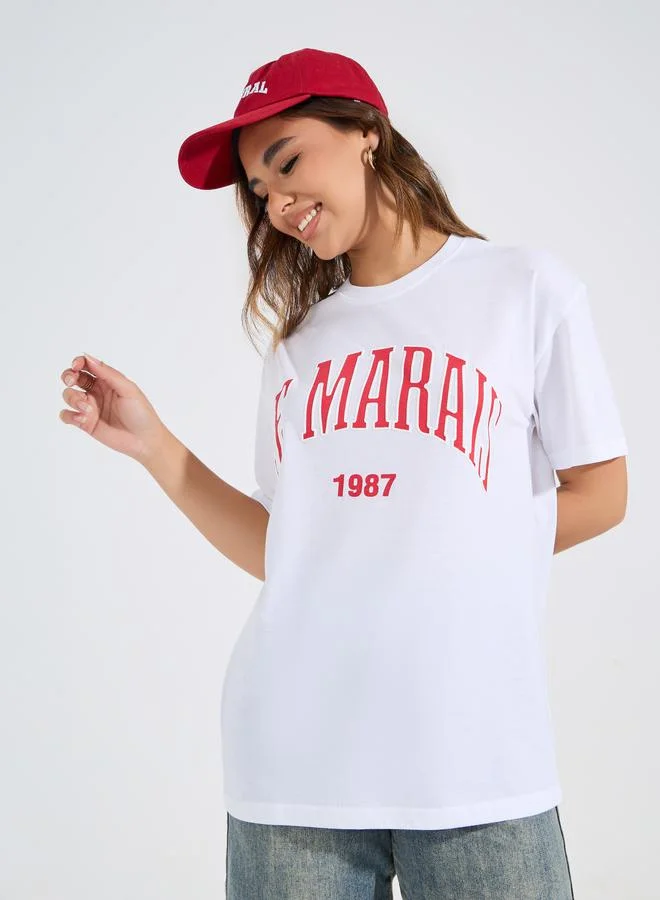 ستايلي تيشيرت Le Marias بطباعة شعار بحجم كبير ورقبة دائرية